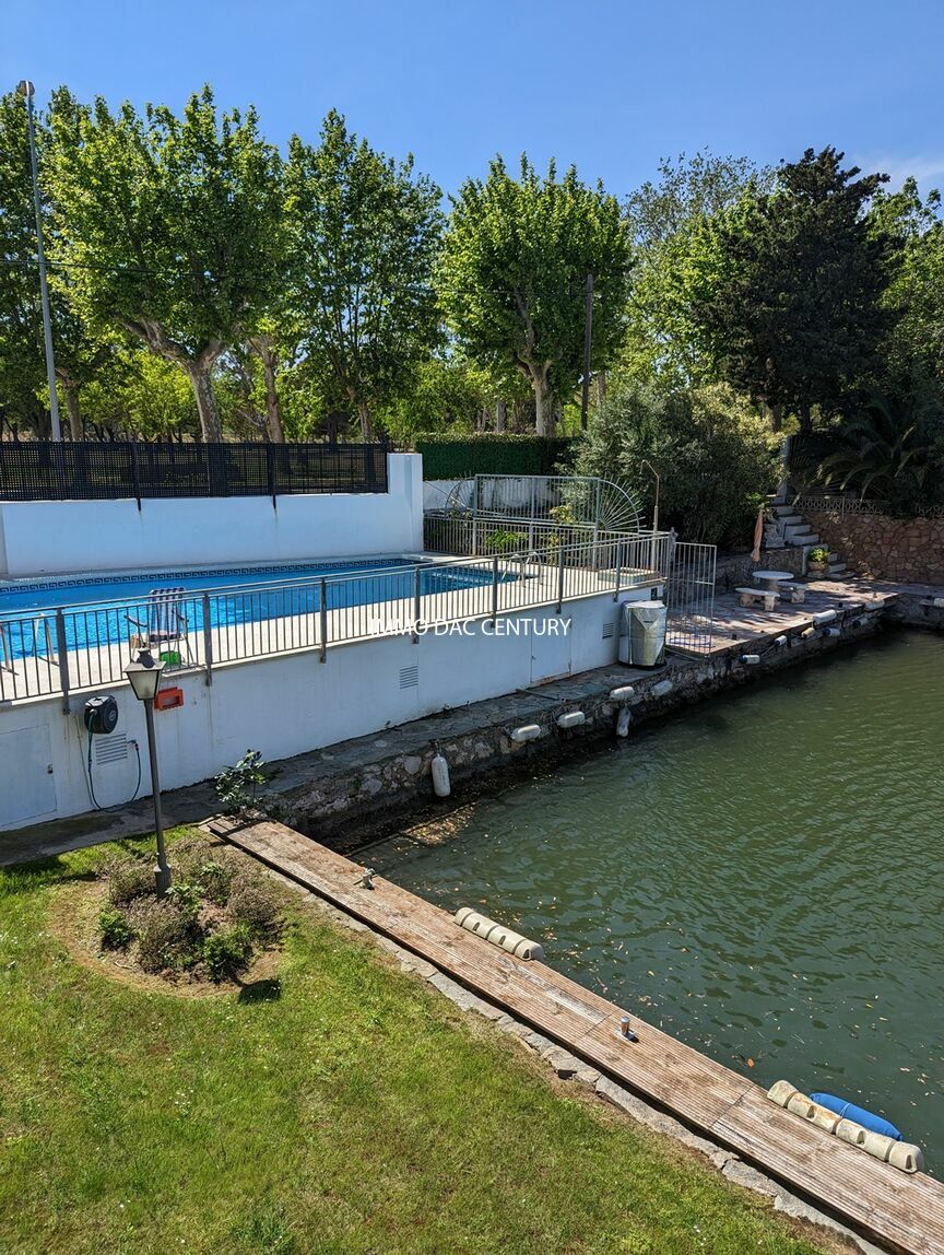 Piso en venta en Empuriabrava con vistas al canal, piscina y amarre comunitario